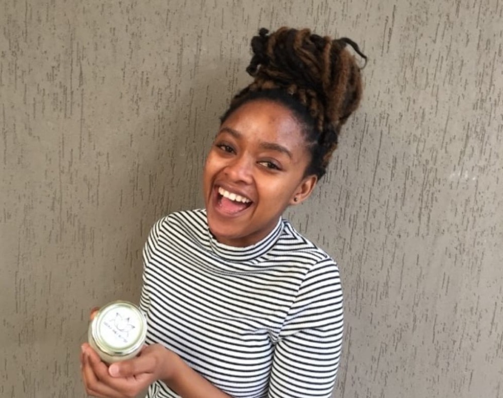 A smiling customer holding her Sienna Shea Butter